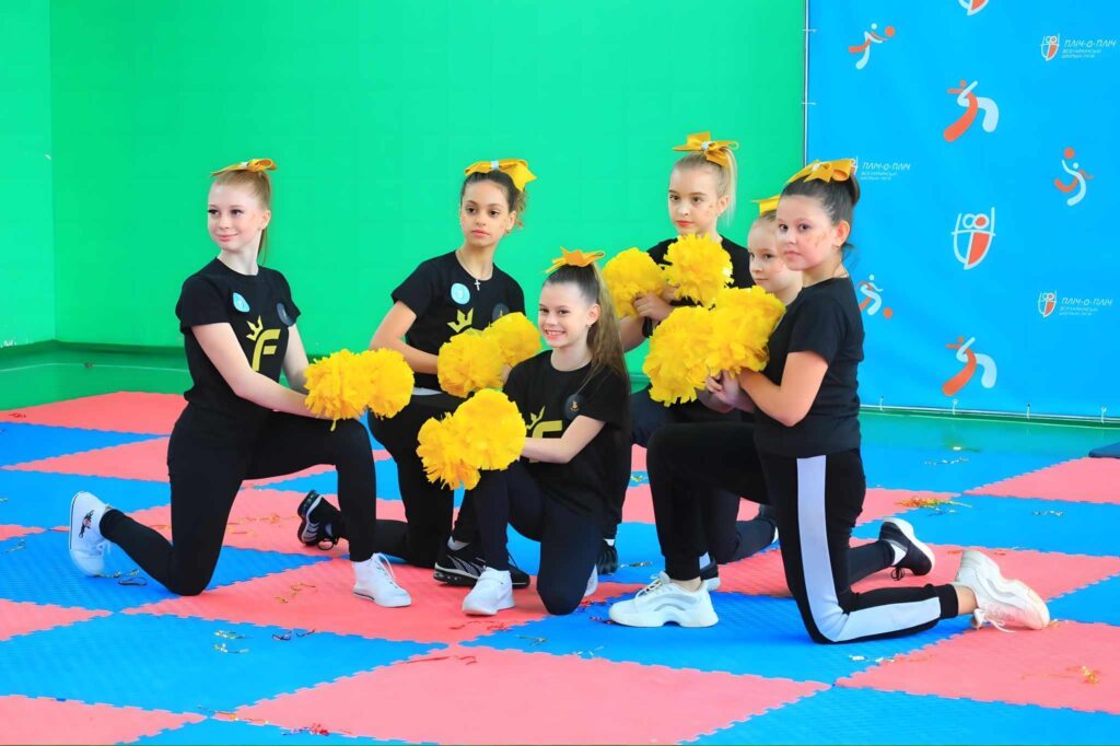 Група дівчаток позує на тлі банера з написом “Пліч-о-пліч Всеукраїнські шкільні ліги”