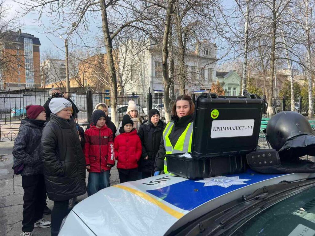 Школярі біля поліцейського автомобіля криміналістів