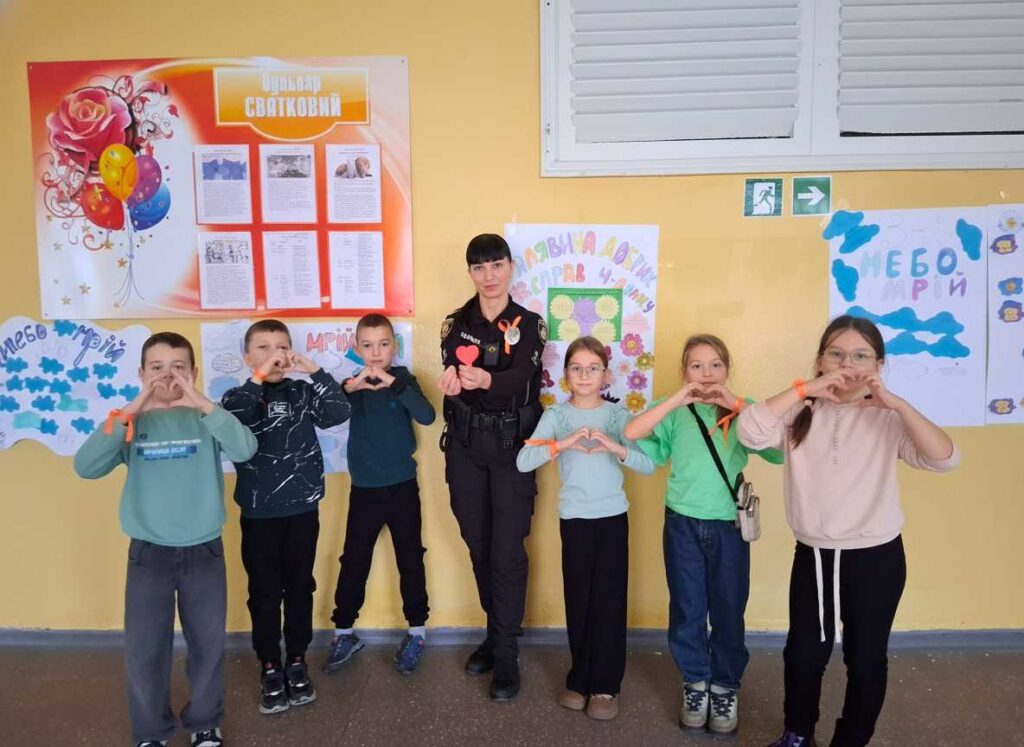 Лейтенант поліції Марина Єрьоміна разом з дітьми показують жест серця руками, символізуючи любов та підтримку