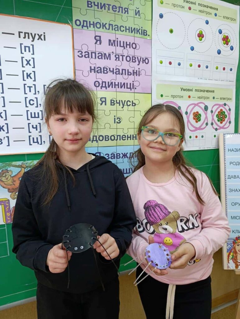 Дві дівчинки тримають паперових павуків — результат Інженерного тижня у ліцеї