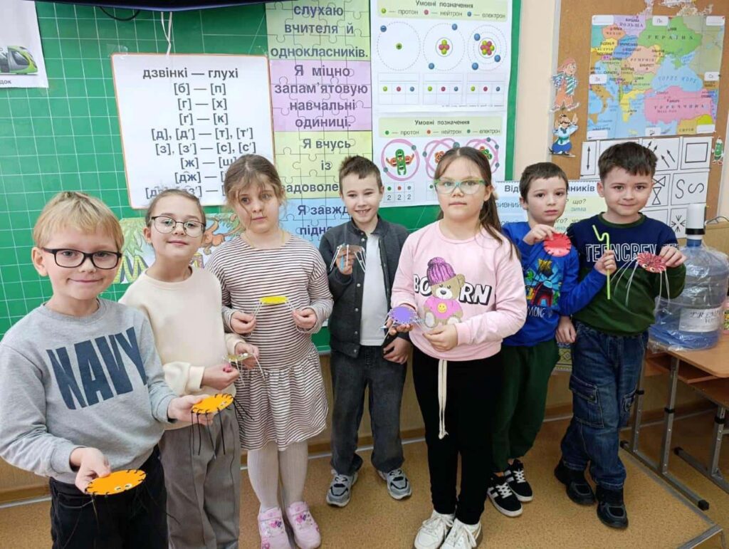 Колективне фото учнів з маленькими виробами в руках на уроці STEM