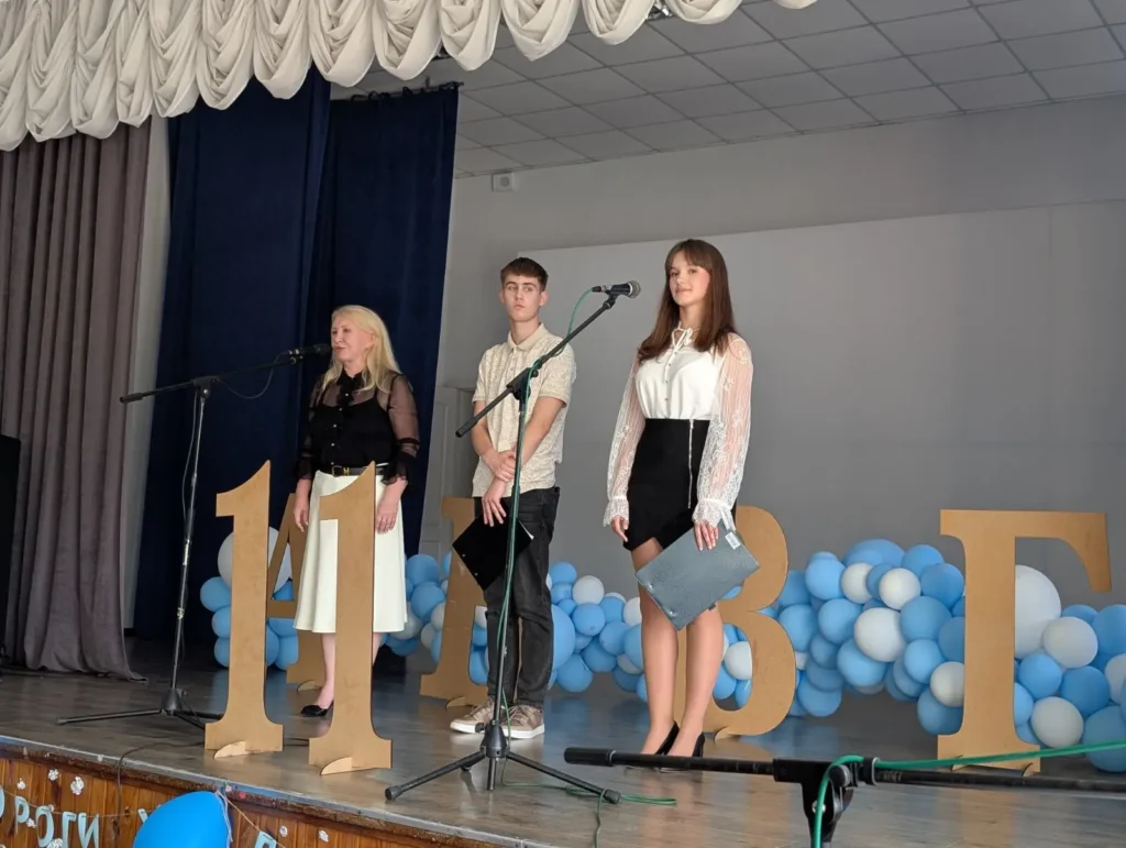 Святково прикрашена сцена актової зали, випускники Кременчуцького ліцею 11